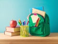 Back to school concept with backpack, pencils and books on wooden table over blue background Royalty Free Stock Photo