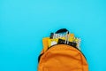 Back to school concept. Backpack with school supplies on blue background. Top view. Copy space. Flat lay Royalty Free Stock Photo