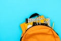 Back to school concept. Backpack with school supplies on blue background. Top view. Copy space. Flat lay Royalty Free Stock Photo