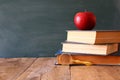 Back to school concept. Blackboard with books and apple Royalty Free Stock Photo