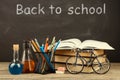 Back to school concept - books on the desk over the blackboard Royalty Free Stock Photo