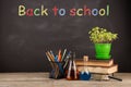 Back to school concept - books on the desk over the blackboard Royalty Free Stock Photo