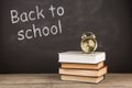 Back to school concept - books on the desk over the blackboard Royalty Free Stock Photo