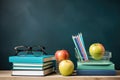 Back to school concept with books, glasses and apple on blackboard background, Glasses, teacher books, and a stand with pencils on Royalty Free Stock Photo