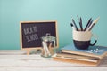 Back to school concept with books, pencils in cup and chalkboard on wooden white table Royalty Free Stock Photo