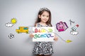 Back to school concept: Cheerful smiling little girl hold paper Royalty Free Stock Photo