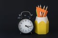 back to school concept. Close up image of school supplies and round clock are on black background. Royalty Free Stock Photo