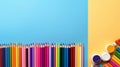 Back to school concept, colored pencils in a row with paints for drawing on a blue background with copy space, top view, flat lay Royalty Free Stock Photo