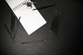 Back to school concept with colour pencils, ink bottle and notepad on black background Royalty Free Stock Photo