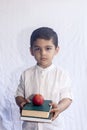 Back to school concept. Cute middle eastern boy holding a stack of books against the white background. Portrait of Central Asian Royalty Free Stock Photo