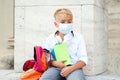 Back to school concept. Education during pandemic. Tired boy in safety mask after lessons. Coronavirus and school life