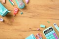 Back to school concept. Frame of turquoise and pink colors school supplies, calculator, pencil case, paper notebook on wooden Royalty Free Stock Photo