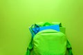 Back to school concept. Green backpack with school supplies on green background. Top view Royalty Free Stock Photo