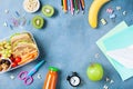 Back to school concept. Healthy lunch box and colorful stationery on blue table top view. Royalty Free Stock Photo