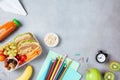 Back to school concept. Healthy lunch box and colorful stationery on table top view.