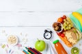 Back to school concept. Healthy lunch box and colorful stationery on white wooden table top view. Royalty Free Stock Photo