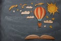 Back to school concept. Hot air balloon, space elements shapes cut from paper and painted over classroom blackboard background. Royalty Free Stock Photo