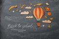 Back to school concept. Hot air balloon, space elements shapes cut from paper and painted over classroom blackboard background. Royalty Free Stock Photo