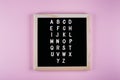 Back to school concept. Letters from A to Z on message board on pink background