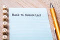 Back to School List concept on notebook and wooden board