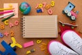 Back to school. Concept with pencils, letters, numbers and sneakers on a cork background. Opened notepad and globe. View from Royalty Free Stock Photo