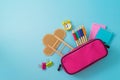 Back to school concept with pink pencil case and school supplies on blue background. Top view flat lay Royalty Free Stock Photo