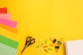 Back to school concept. School stationery with colored paper, scissors, paper clips and a notebook on a bright yellow background. Royalty Free Stock Photo