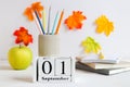 Back to school concept. School stationery, green apple and calendar dated September 1st on the table. Selective focus