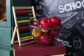 Back to school concept. School supplies, abacus, basket red apples on stack of books on background of chalkboard. Teachers day. Bl Royalty Free Stock Photo