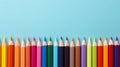 Back to school concept, sharp rainbow colored pencils in a row isolated on blue background with copy space, top view, flat lay Royalty Free Stock Photo