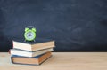 Back to school concept. stack of books over wooden desk in front of blackboard. Royalty Free Stock Photo