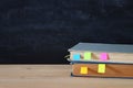 Back to school concept. stack of books over wooden desk in front of blackboard. Royalty Free Stock Photo