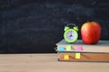 Back to school concept. stack of books and pencils over wooden desk in front of blackboard. Royalty Free Stock Photo