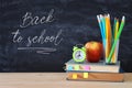 Back to school concept. stack of books and pencils over wooden desk in front of blackboard. Royalty Free Stock Photo