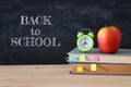 Back to school concept. stack of books and pencils over wooden desk in front of blackboard. Royalty Free Stock Photo