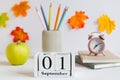 Back to school concept. School stationery, green apple, alarm clock, pencils and calendar dated September 1st on the