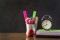 Back to school concept. School supplies, alarm clock and apple. Copy space on chalkboard. Royalty Free Stock Photo