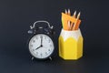 Back to school concept. School supplies and round clock are on black background. Royalty Free Stock Photo