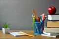 Back to school concept, school supplies, stack of books, red apple, succulent in a white pot and an open notebook on a wooden Royalty Free Stock Photo