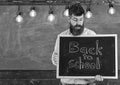 Back to school concept. Teacher in eyeglasses holding chalkboard with sentence back to school written in it. Man with Royalty Free Stock Photo