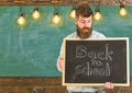 Back to school concept. Teacher in eyeglasses holding chalkboard with sentence back to school written in it. Man with Royalty Free Stock Photo