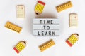 Back to school concept. The text time to learn in a lightbox, on a white background and surrounded by fondant cookies