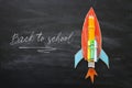 Back to school concept. Top view image of handmade cardboard rocket and clouds with pencils over classroom blackboard background Royalty Free Stock Photo