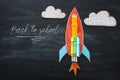 Back to school concept. Top view image of handmade cardboard rocket and clouds with pencils over classroom blackboard background Royalty Free Stock Photo