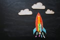 Back to school concept. Top view image of handmade rocket and clouds with pencils over classroom blackboard background. Royalty Free Stock Photo