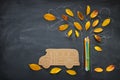 Back to school concept. Top view image of school bus and pencils next to tree sketch with autumn dry leaves over classroom blackbo Royalty Free Stock Photo