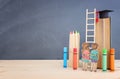 Back to school concept. Top view image of two kids standing next to ladder and book over wooden desk