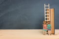 Back to school concept. Top view image of two kids standing next to ladder and book over wooden desk Royalty Free Stock Photo