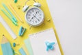 Back to school concept. Top view photo of alarm clock notepads pencil-case plane shaped sharpener ruler pens binder clips and