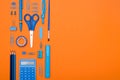 Back to School concept. Top view school supplies on a student desk on orange background. Flat lay and copy space Royalty Free Stock Photo